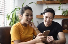 Young couple shops for insurance rates on a smartphone.