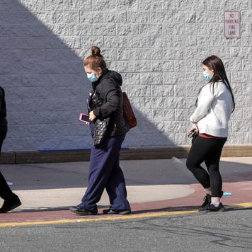 People wait outside a grocery store during the pandemic.