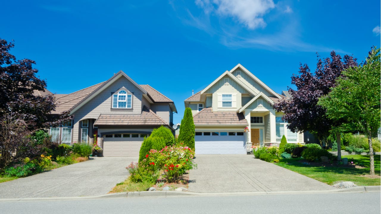 Two homes with adjacent driveways and landscaping