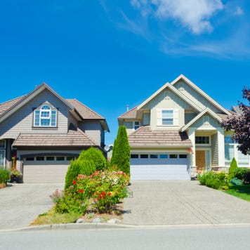 Two homes with adjacent driveways and landscaping