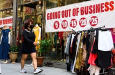 A woman walks by a store going out of business in New York City.