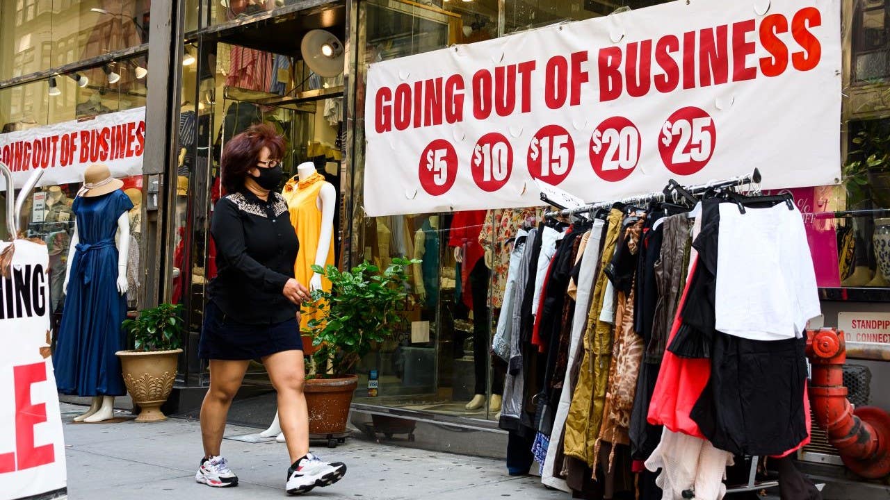 A woman walks by a store going out of business in New York City.