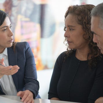 A financial expert is going over the particulars of an insurance policy with a couple who are clients.