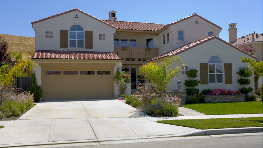 A Mediterranean-style two-story home with attached front-facing garage