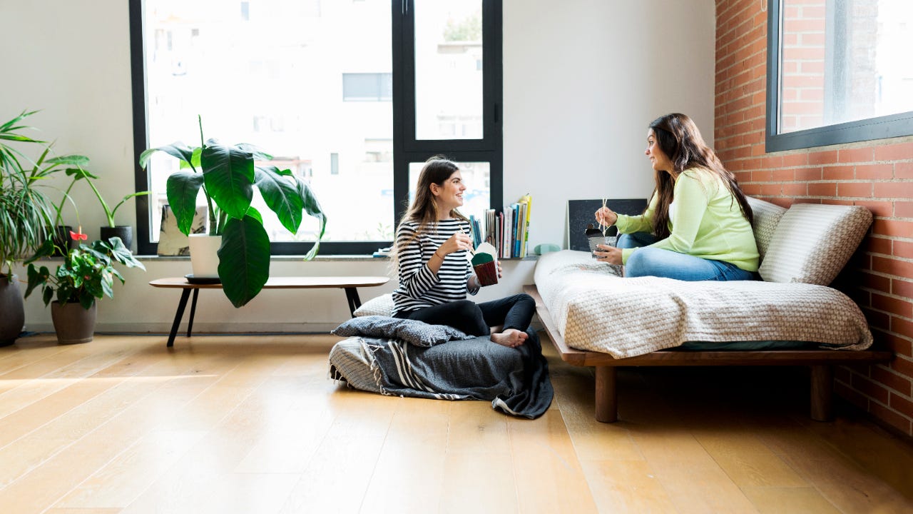 Two women having takeout food at home