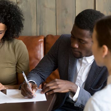 A couple signs mortgage documents