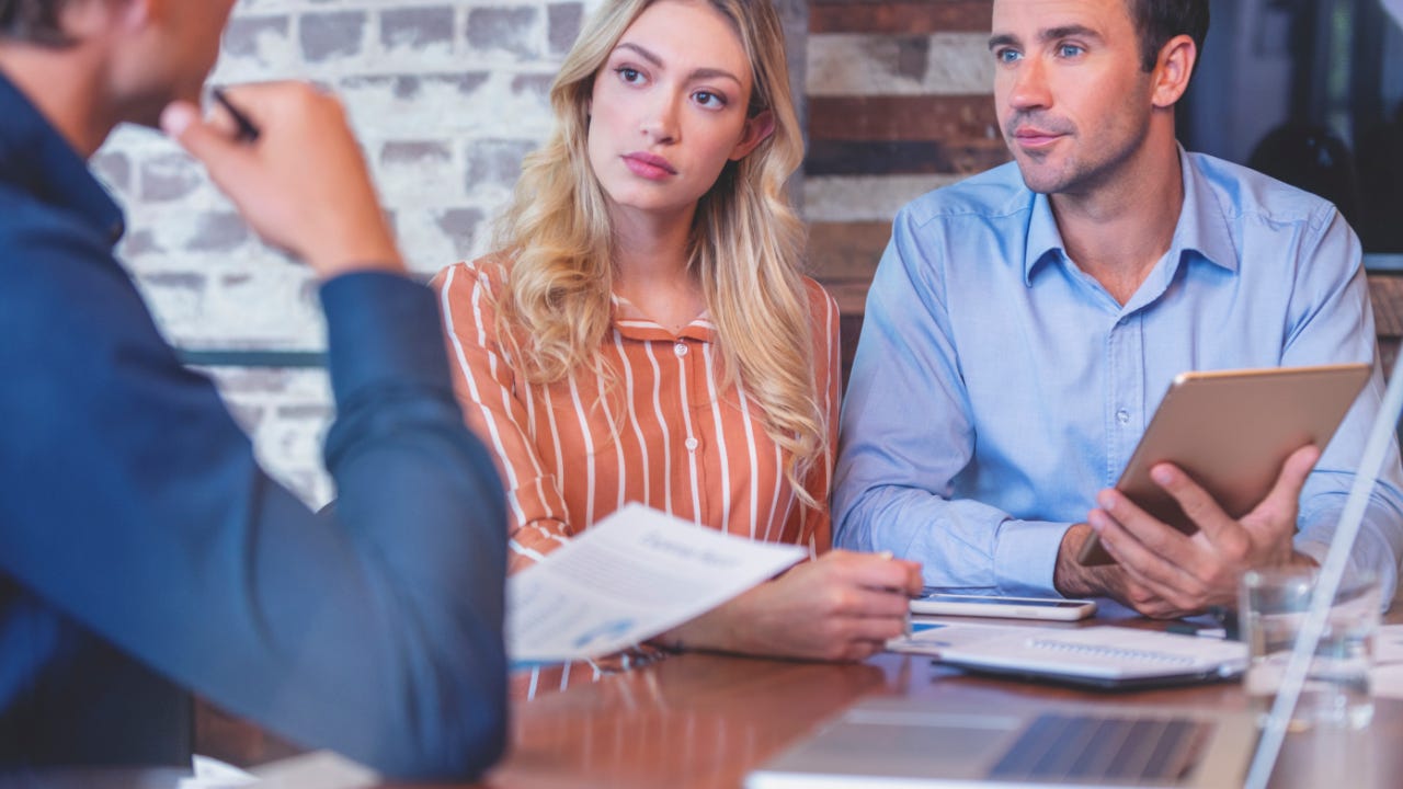 Young couple speaking to a banker