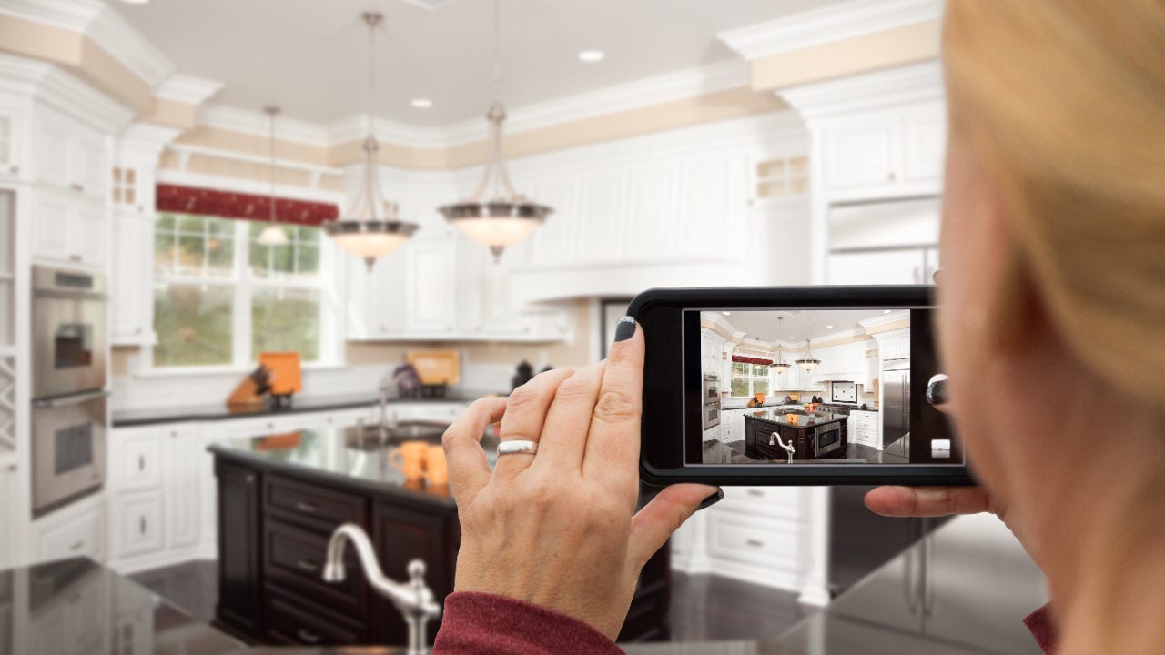 Close-up of hands taking a phone video in a kitchen