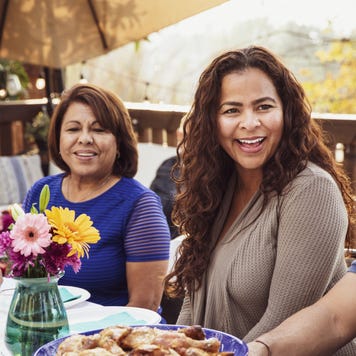 Hispanic family enjoying a nice dinner out on the porch.