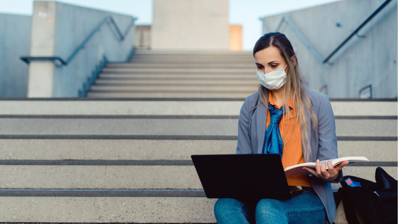 Student works on laptop while wearing mask