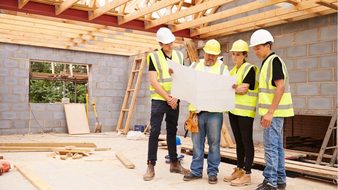 A construction crew evaluates the floor plan of a new home