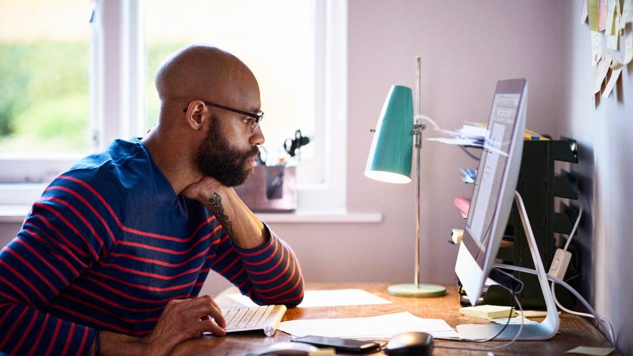 A Black entrepreneur looks over his computer