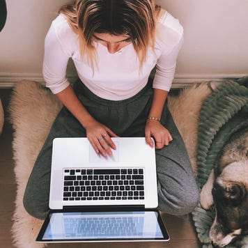 A young woman works from her laptop.