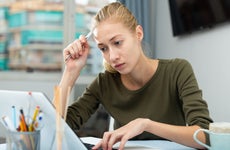 Woman looks concerned while working on laptop