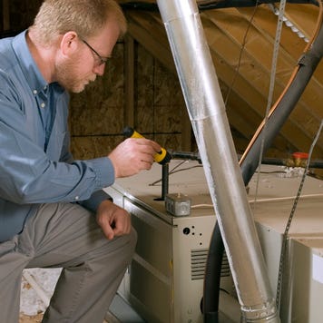 A home inspector assesses the attic in a home.