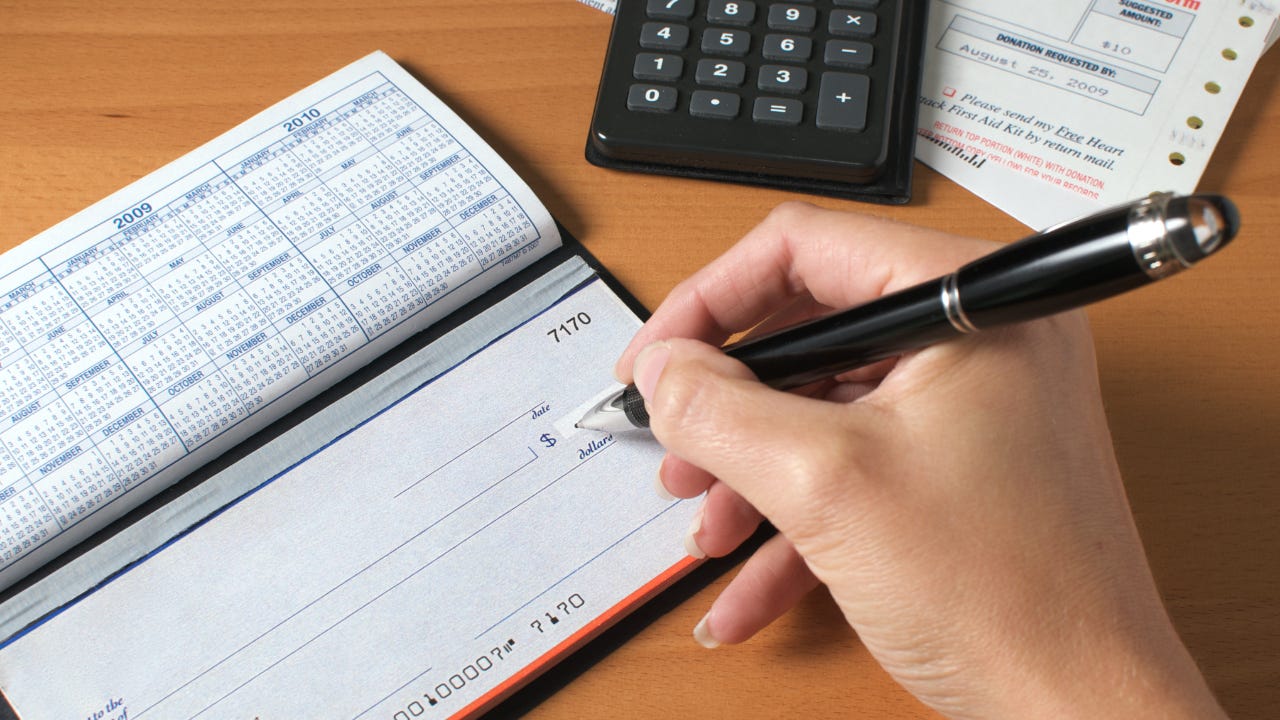 A woman writes a check