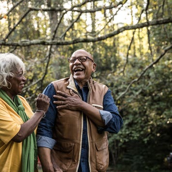 Two older homeowners take a walk in the park.