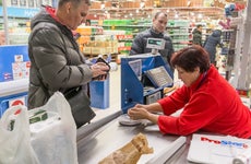 A man buys groceries with cash.