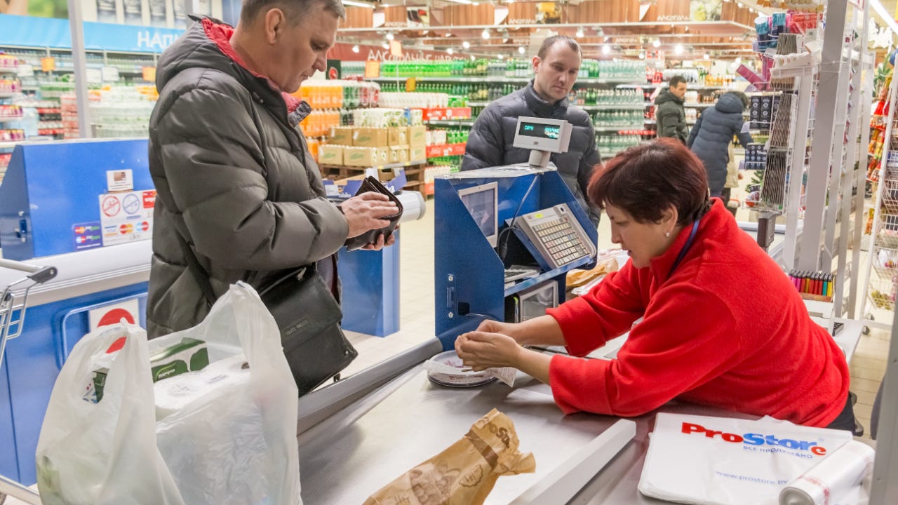 A man buys groceries with cash.