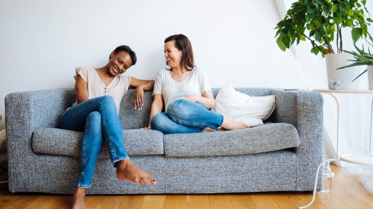 Two newly-minted homeowners relax on the couch in their new place.
