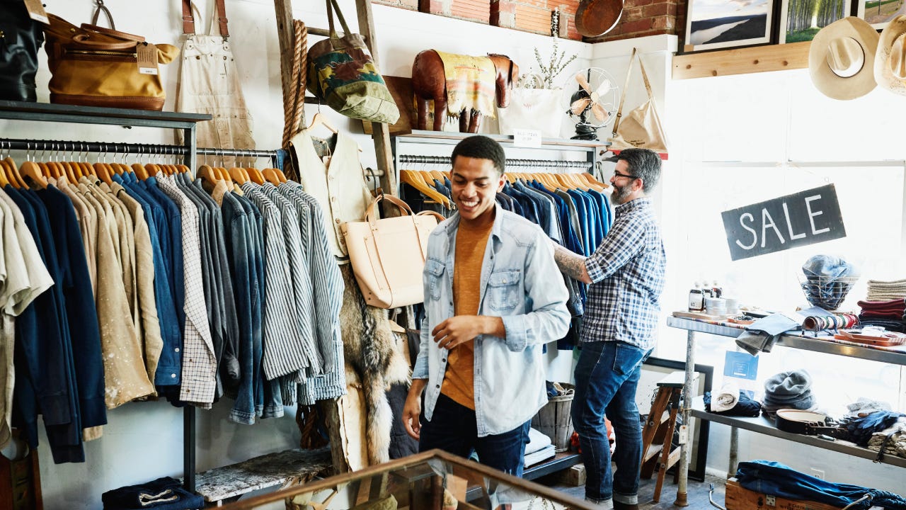 Smiling customers shopping in mens boutique