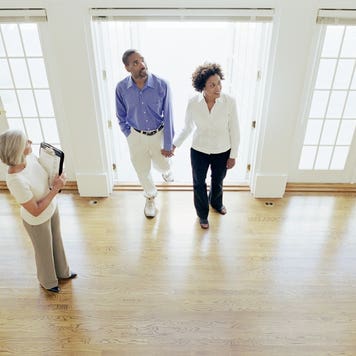 A real estate agent shows buyers a vacant home.