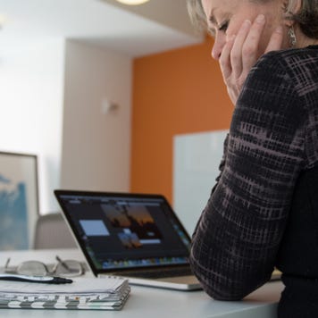 An older woman works on her laptop.