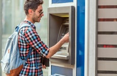 A young man uses an ATM.