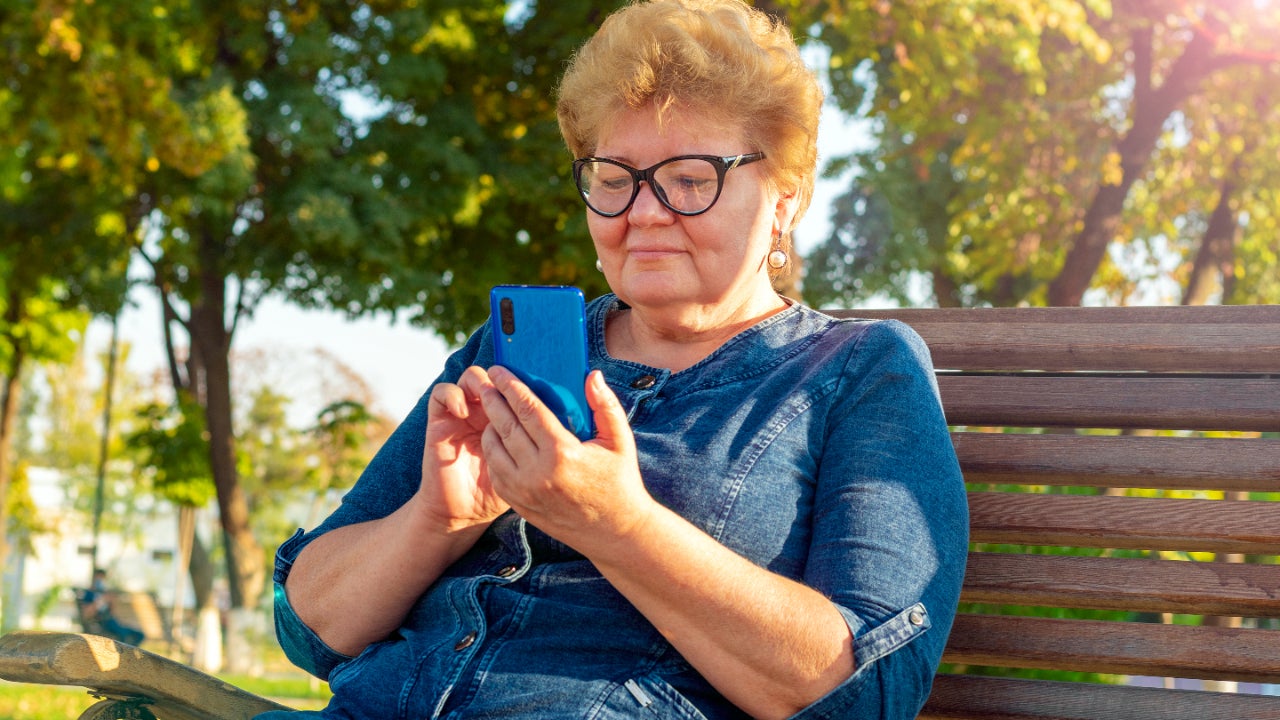 A senior woman goes on her smartphone.