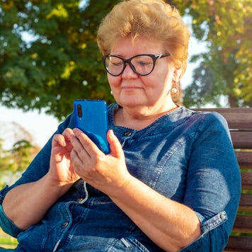 A senior woman goes on her smartphone.