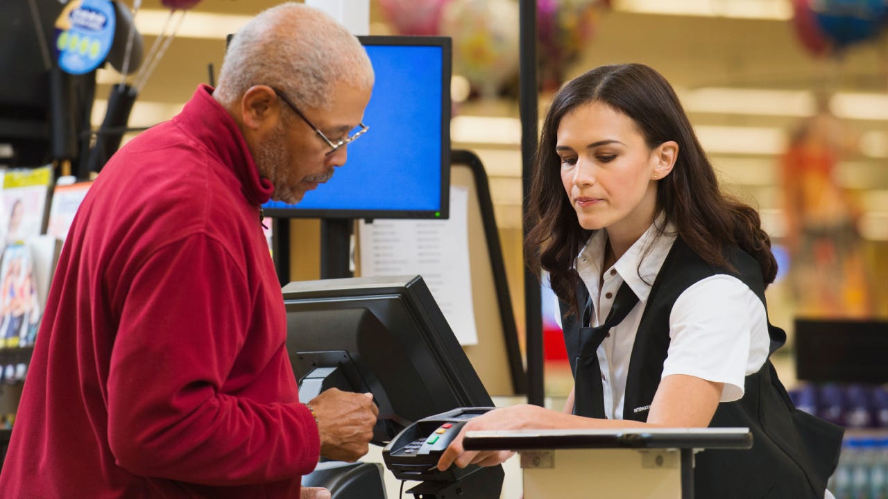 Cashier and customer at grocery store checkout