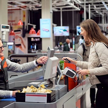 young lady paying at a counter of a store with a card
