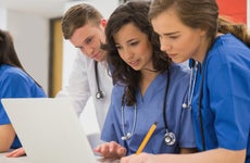 Nurses look at a laptop together