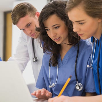 Nurses look at a laptop together