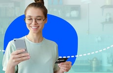 Person looking at phone and holding credit card