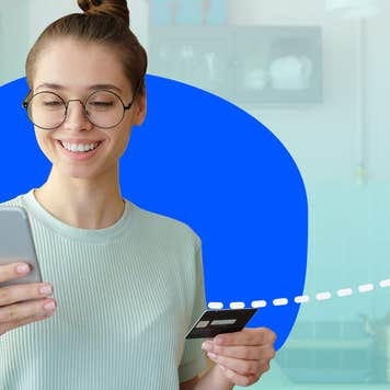Person looking at phone and holding credit card