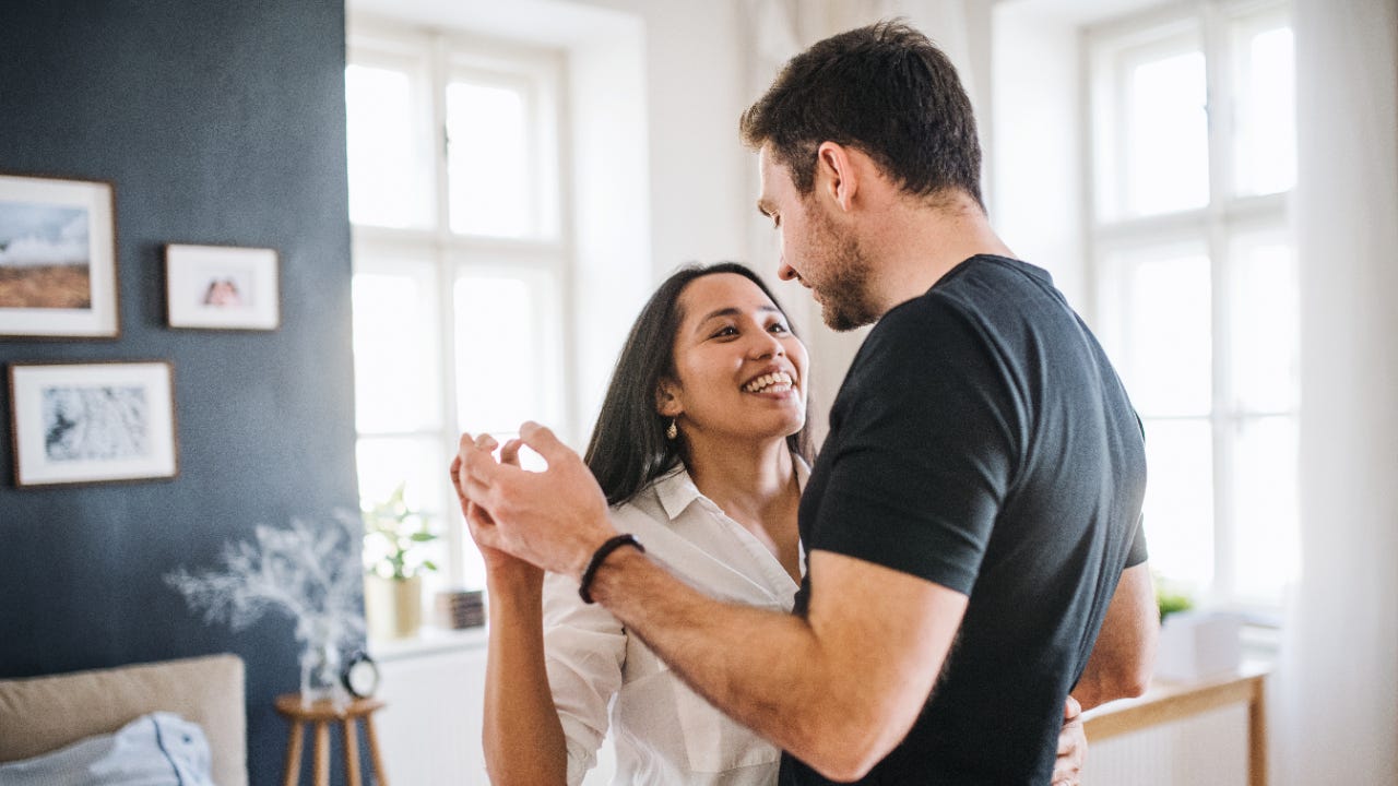 A White couple dances in their living room