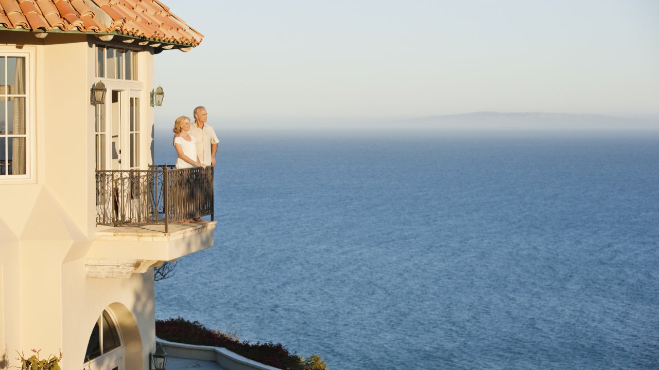 couple on balcony of home overlooking ocean