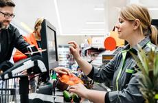 A cashier at a supermarket rings up a customer's items.