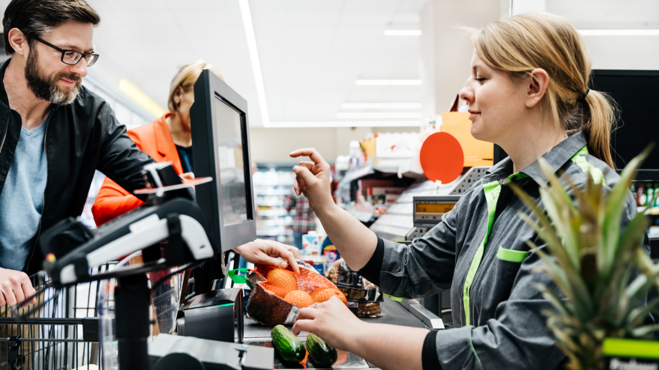 A cashier at a supermarket rings up a customer's items.