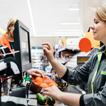 A cashier at a supermarket rings up a customer's items.