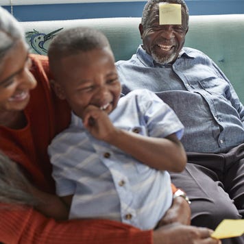 A grandson is playing with his grandparents in the living room.