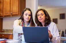 Mother and daughter paying bills online