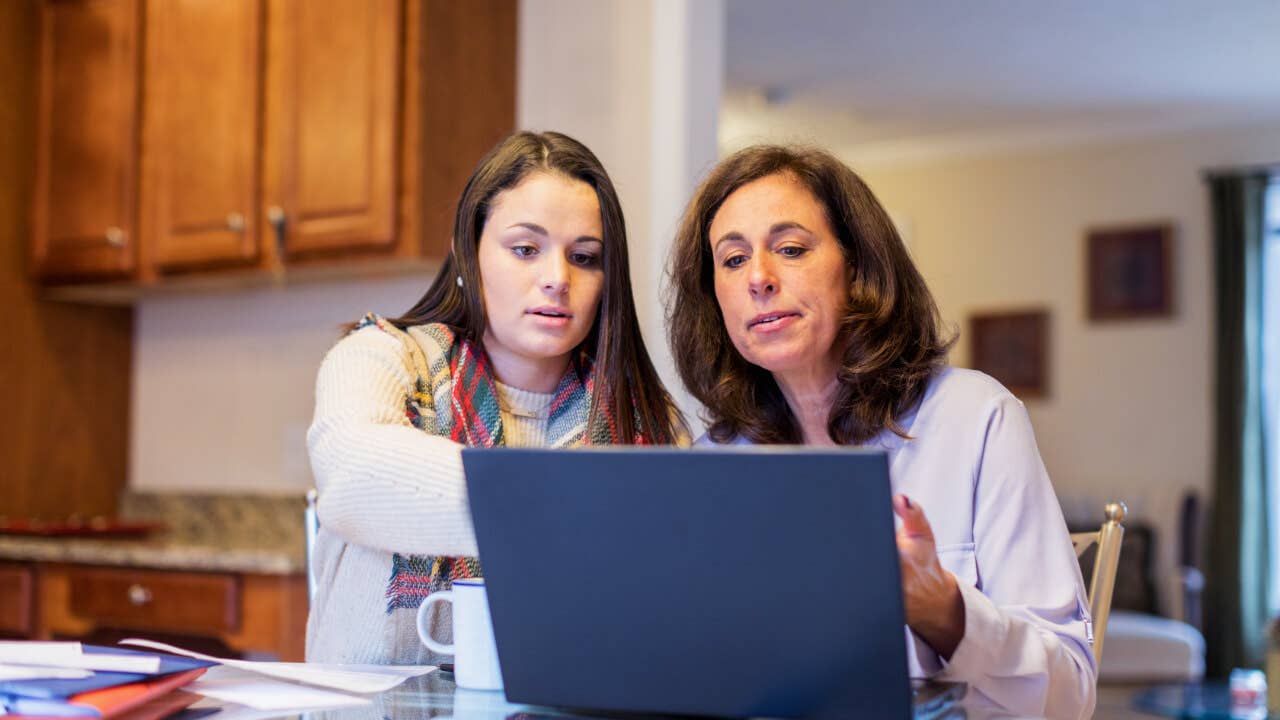 Mother and daughter paying bills online