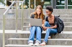 Two college students sit on steps outside