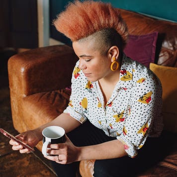 woman sitting on couch and looking at her phone