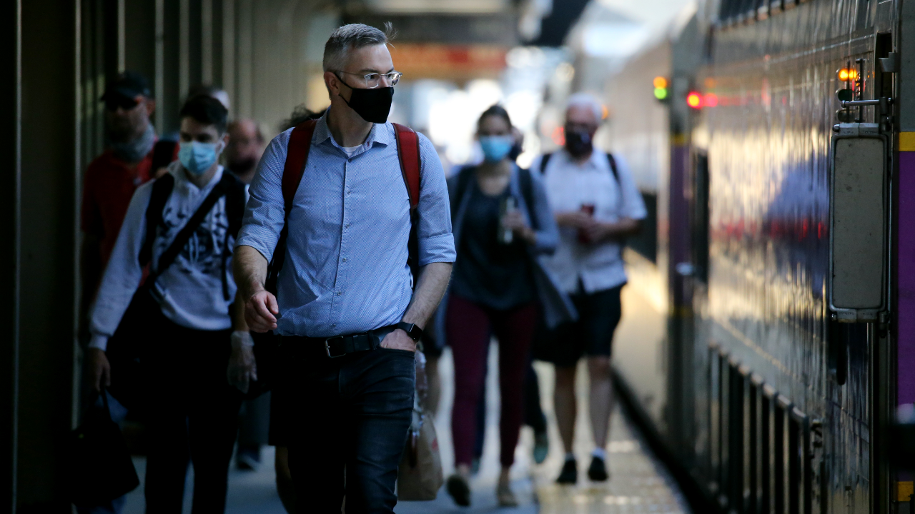 Commuters arrive at South Station in Boston wearing masks.
