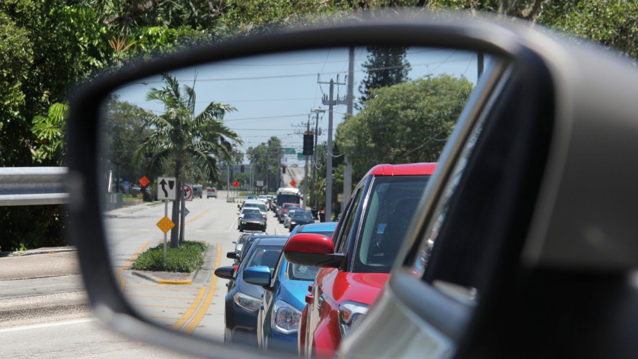 View of Florida traffic through a side mirror in a car.