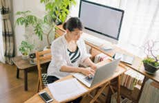 An Asian-American woman trads stocks from her home office computer