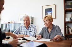 An older couple sits at a desk across from an insurance expert.